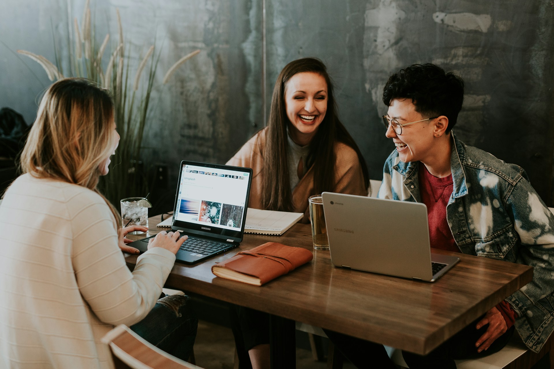 A group of young people working together on their laptops and laughing - Photo by Brooke Cagle on Unsplash