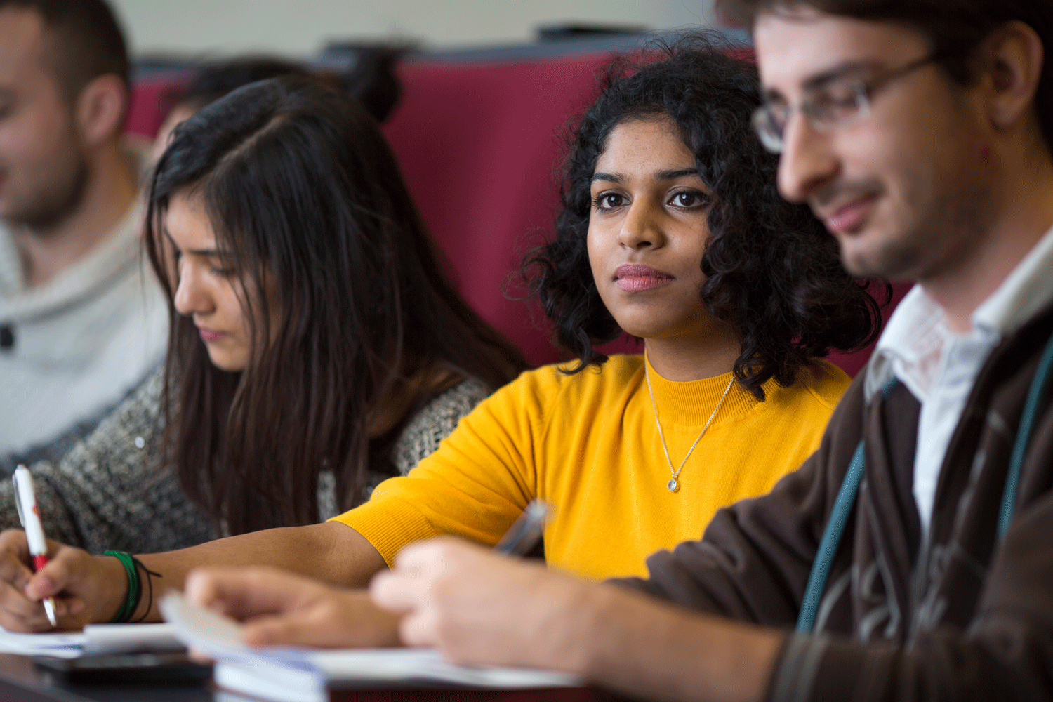 A photo of two women and a man at a university lecture
